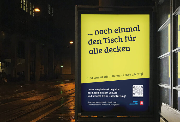 Ökumenischer Ambulater Hospiz- und Kinderhospizdienst Rostock und Kühlungsborn Plakat mit der Aufschrift "Noch einmal den Tisch für alle decken
